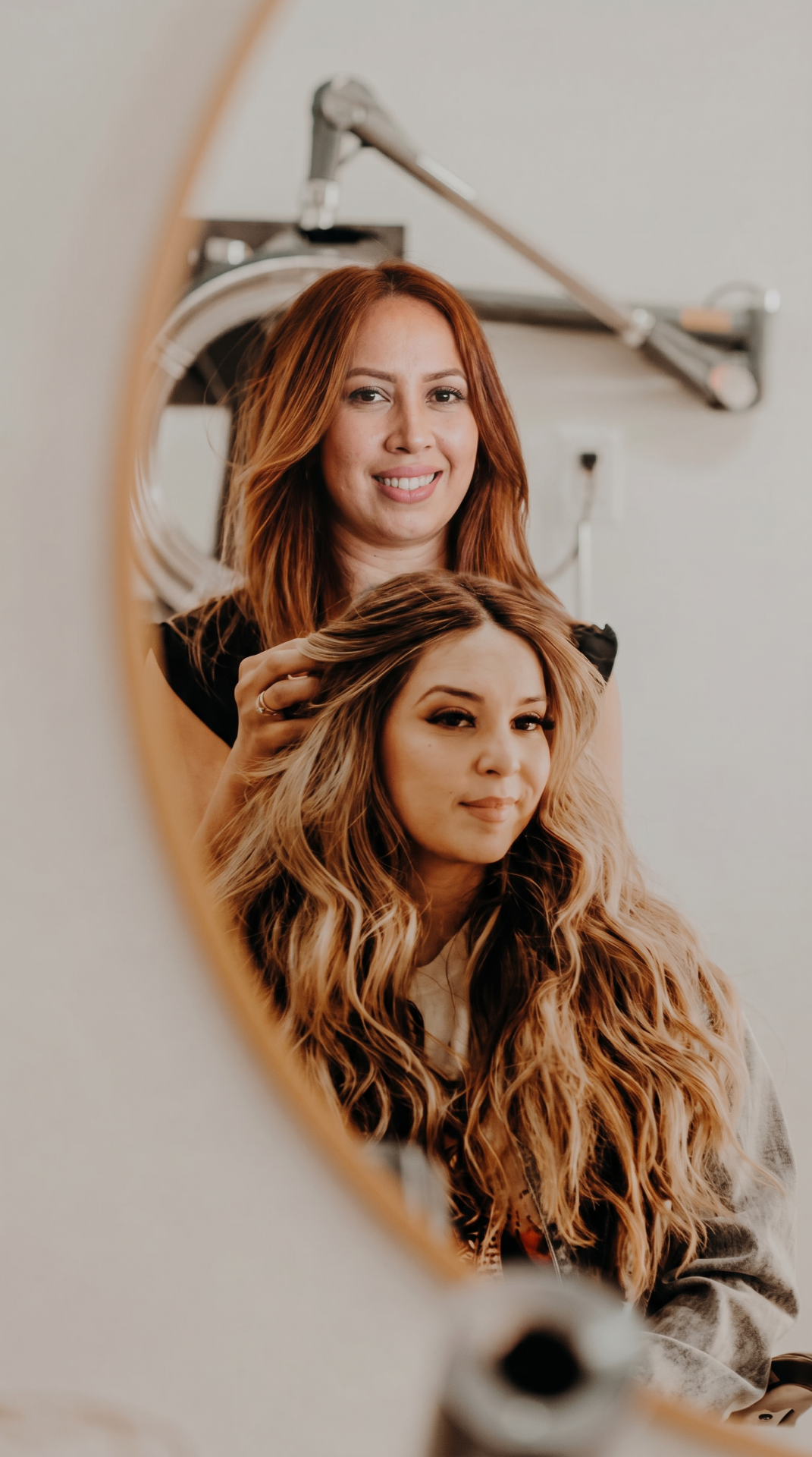 Cynthia trabajando el cabello de una clienta frente al espejo